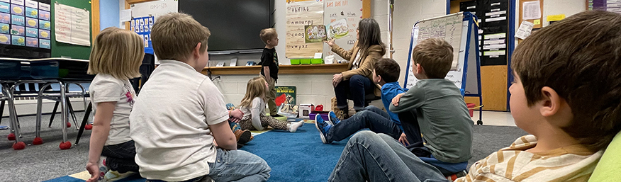 Kindergarten students enjoying story time with Superintendent Stanton